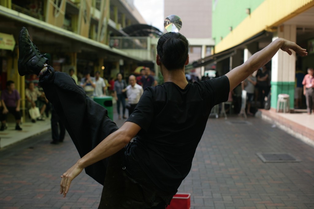 WARM UP: Daisuke Onoe, who goes by the performance name of Jonasun, warms up in front of a small but slowly growing curious crowd in Chinatown.