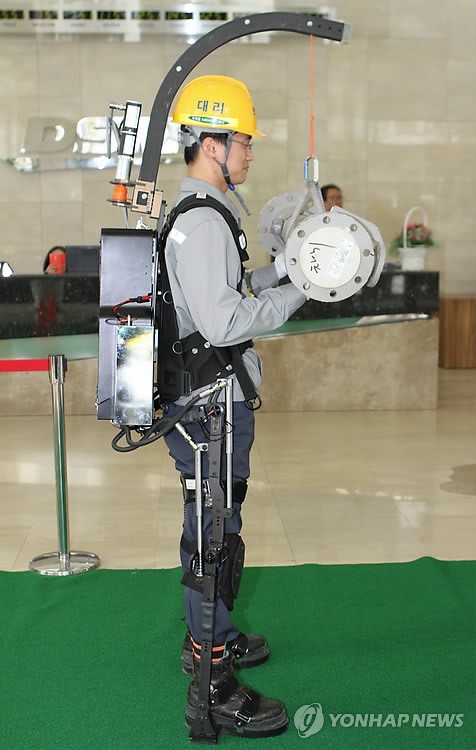 The exosuit is extensible with a crane that helps lift the load.