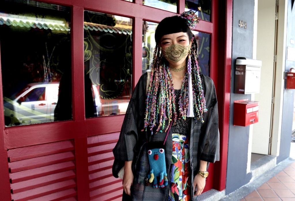 Kelly with her yarn braids, which took her five hours to put in. She is wearing her own crocheted face mask and knitted top as well.