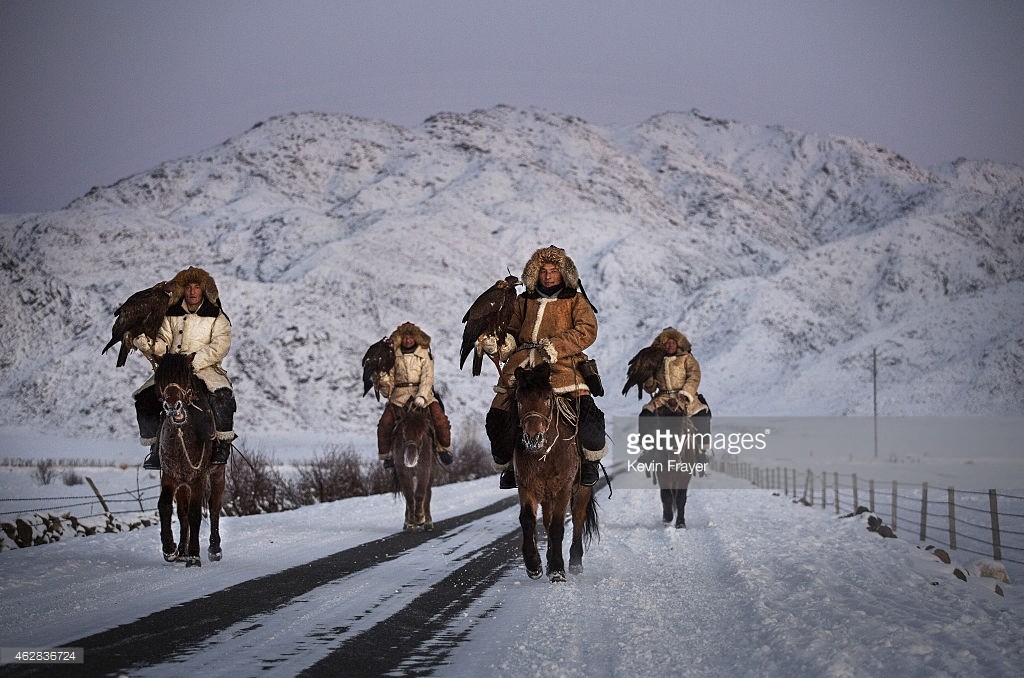 XINJIANG, CHINA - JANUARY 29:  Chinese Kazakh eagle hunters from the Beysenbay family who are all brothers ride together with their eagles before a local competition on January 29, 2015 in the mountains of Qinghe County, Xinjiang, northwestern China. 