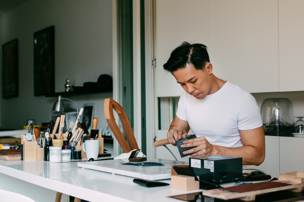 Roy uses a filtuese manuelle (also known as a hot creasing iron) to smooth out the leather and seal the edgecoat into the leather